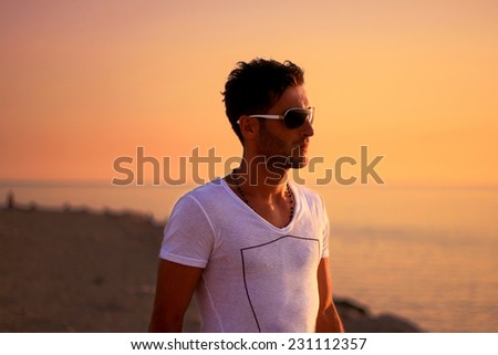 young attractive tourist looking to the sunset at beach