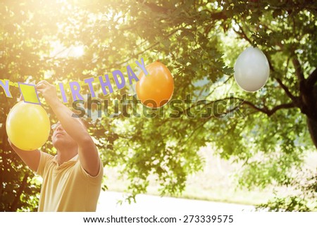man hanging up ballons to preparing the birthday party