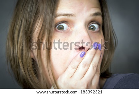 portrait of scared woman with hands on her face