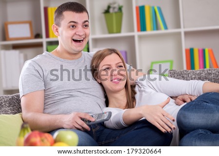 Couple smiling and watching comedy movie