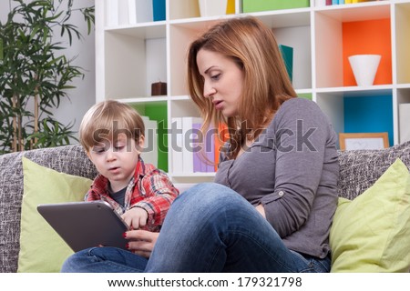 Adorable mother and son pointing  tablet