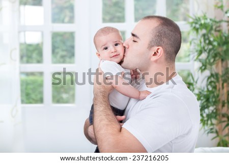 Young Father hugging and kissing his little son