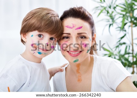 Smiling happy family with colors on them face - funny moments