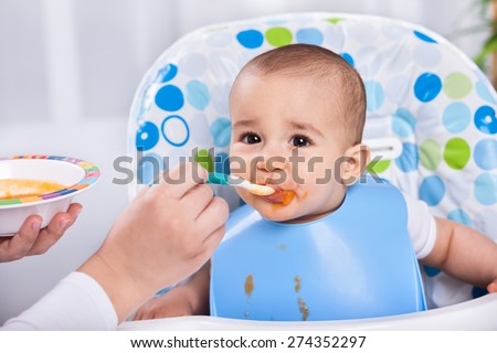 Beautiful messy baby child likes to eat