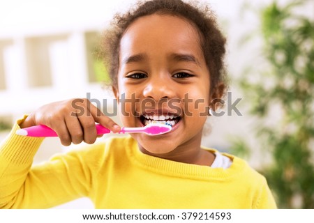 Little beautiful african girl brushing teeth, healthy concept