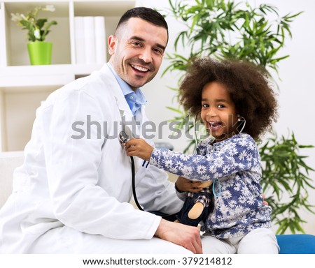 Smiling pediatrician and his happy little patient exam with stethoscope