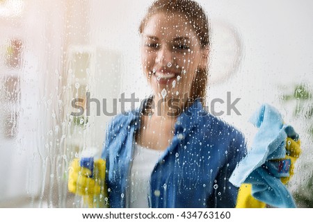 Woman cleaning window with special cleaner