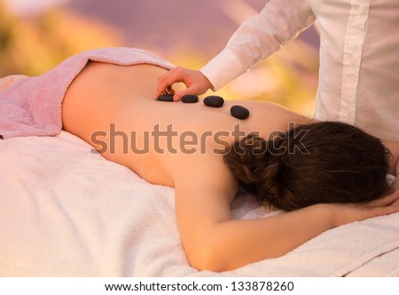zen stone massage - girl on towels with masseuse