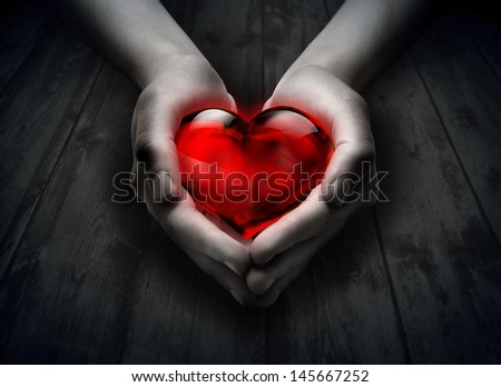 glass heart in the heart hand