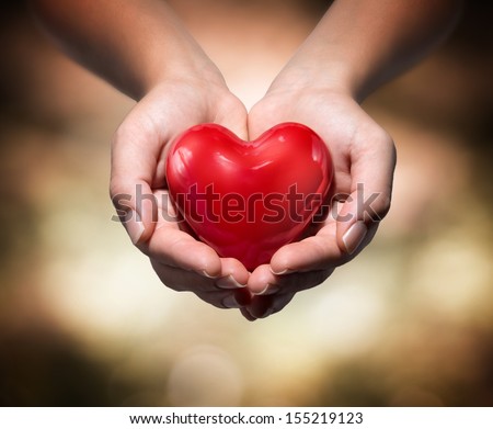 heart in heart hands- warm background