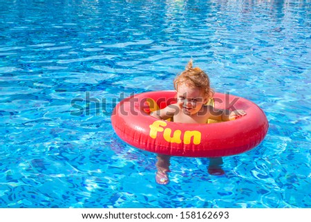 Beautiful little girl whit donut float in the pool - fun