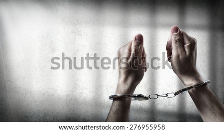 arrest  - man handcuffed in cell prison