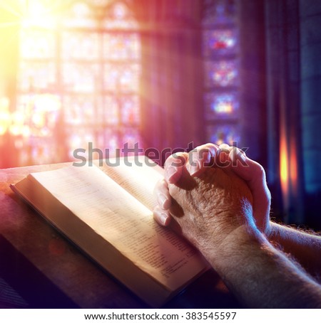 Hands Of A Man Praying With Bible