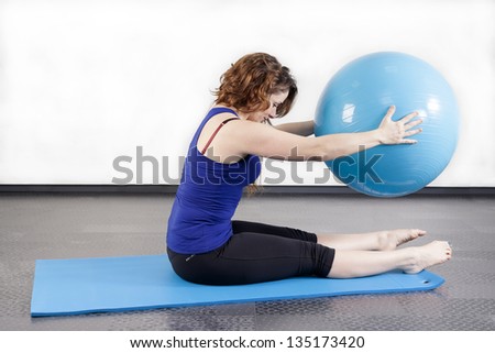 woman doing pilates ball on the floor