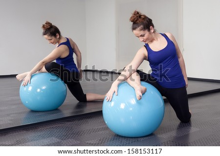 woman doing pilates ball on the floor in the mirror