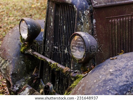A shallow depth od field photo of the headlight on a run down old truck.