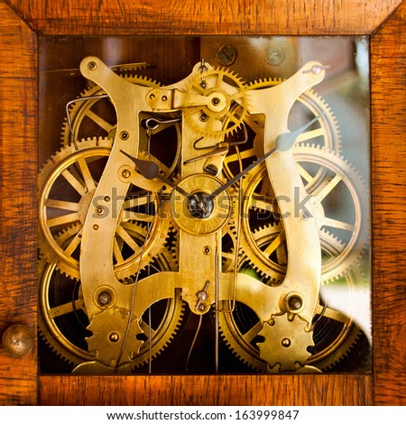 Old clock with a glass face showing the interior gears