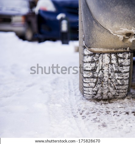 Detail of a winter tire caked with snow
