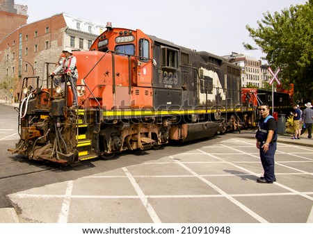 MONTREAL, QC, CANADA-August 3, 2014:  A CN Rail locomotive crosses an intersection in old Montreal on August 3, 2014.