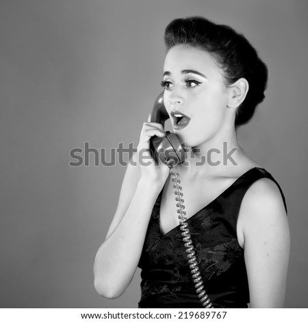 Close up of a beautiful young girl using an old green phone surprised expression in black and white