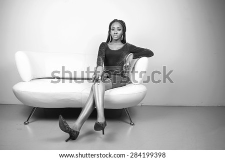 Beautiful fashion model on a white couch in black and white