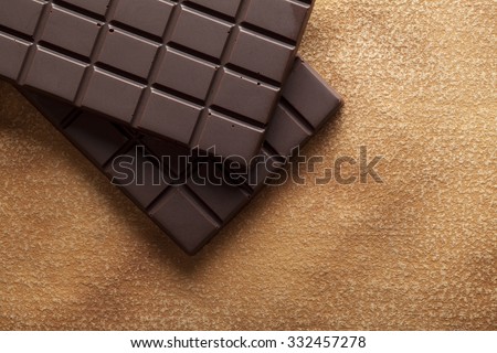 Dark chocolate bar on brown handmade paper background