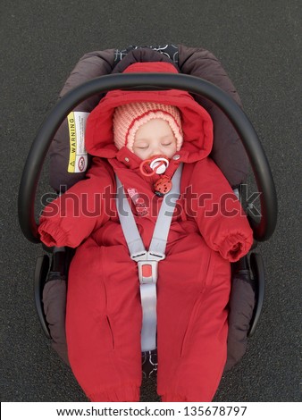 The baby sleeps in a children\'s car seat