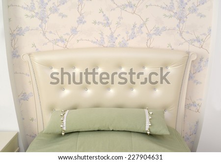 Headboard of a single bed with a throw pillow. Modern classics with rococo elements