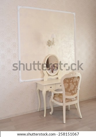 Dressing table and white chair in a hotel room \