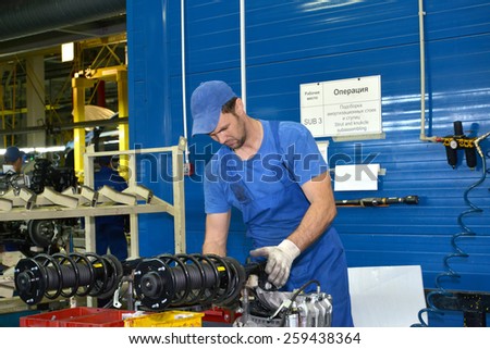 KALININGRAD, RUSSIA - SEPTEMBER 16, 2014: The worker selects depreciation racks for cars. Assembly shop of automobile plant