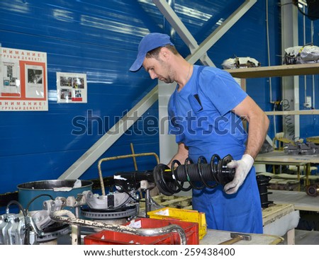 KALININGRAD, RUSSIA - SEPTEMBER 16, 2014: The worker selects depreciation racks for cars. Assembly shop of automobile plant