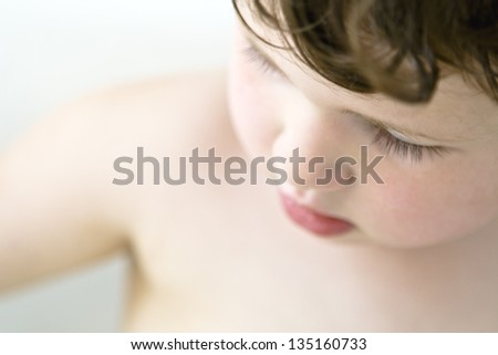 Boy in the Bathtub Looking Down: A boy in bathtub looking down.  The focus is on his eyelashes.