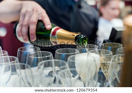 champagne being poured into a champagne flute  by waitstaff