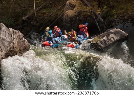 A group of men in an inflatable dinghy in the white water rafting