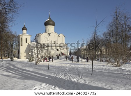 PSKOV, RUSSIA - JANUARY 24, 2015: People and children are having fun near the ancient church in a sunny winter day