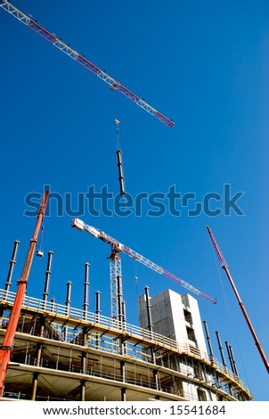 building yard with cranes against a clean blue sky