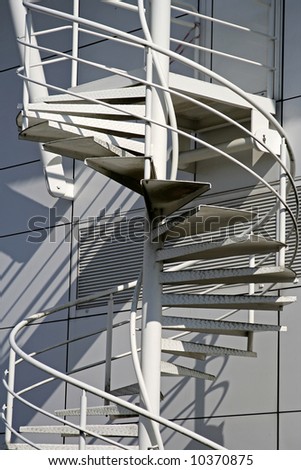 metal white spiral stairs on the outside of a factory