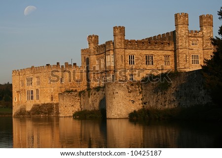 the sun doing down on Leeds castle with moon in the sky
