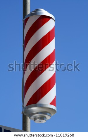 striped barbers pole set against bright blue sky