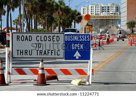 road closed sign and road construction next to beach