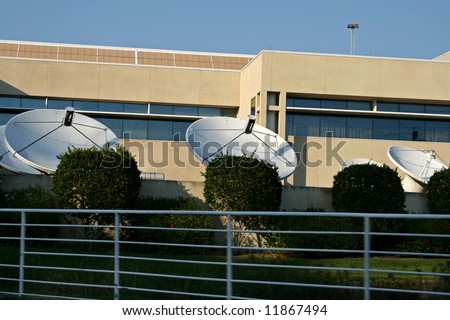 rows of media satellite dishes outside tv station