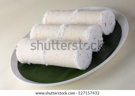 White rice Puttu.a South Indian and Sri Lankan breakfast dish of steamed cylinders of ground rice layered with coconut. Puttu is served with side dishes such as palm sugar or chickpea curry or banana.