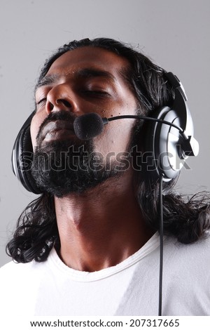 Portrait of man with headphones with beard and long hair.