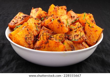 Bombay Potato is a hot and spicy accompaniment for curry can be eaten as a snack with bread,parathas,chapati and rice.Shallow depth of field photograph.