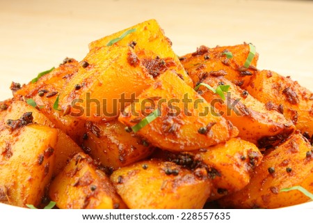 Spicy fried potatoes with herbs and spices. Shallow depth of field photograph.