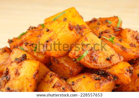 Spicy fried potatoes with herbs and spices. Shallow depth of field photograph