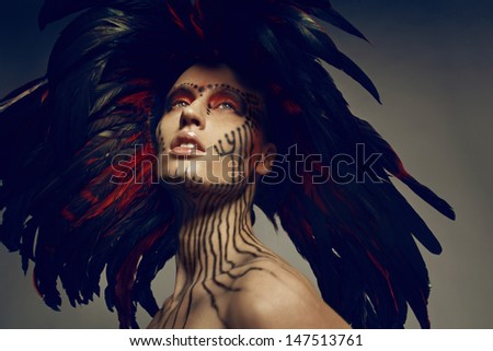 Fashion studio shot of beautiful woman with feathers. Air brush make-up.