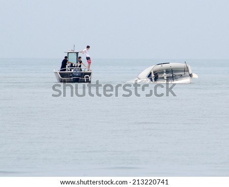 Saint Joseph Michigan, Circa June, 2014.  an instructor watches kids on a capsized boat, as they learn about water safetly at the  St Joseph Junior foundation sailing camp
