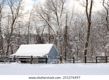 Blue barn in a rural winter setting with snow frosted trees