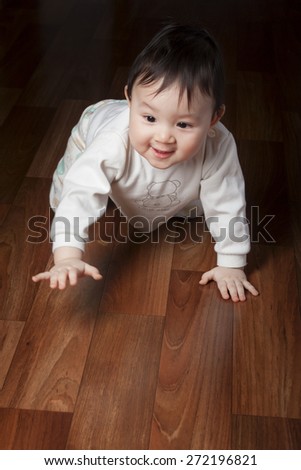 baby crawling on the floor. baby crawls on all fours. Photo in low key